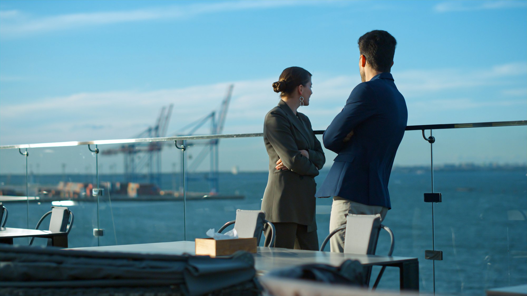 Couple looking sea terrace in morning sunlight. Business partners enjoy view